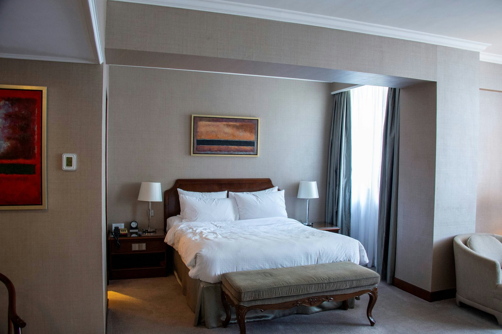 Elegant hotel bedroom with white linens and wooden furniture in Dodoma, Tanzania