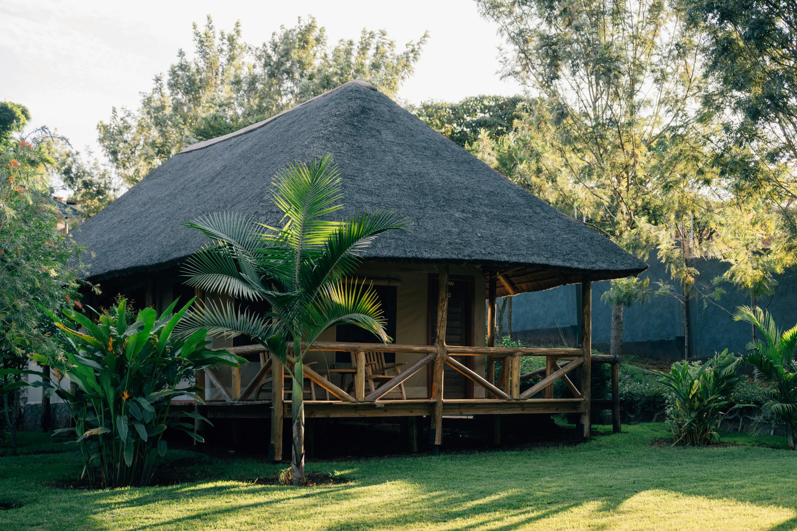 Thatched-roof banda bungalow in a lush garden, typical East African accommodation near Dodoma
