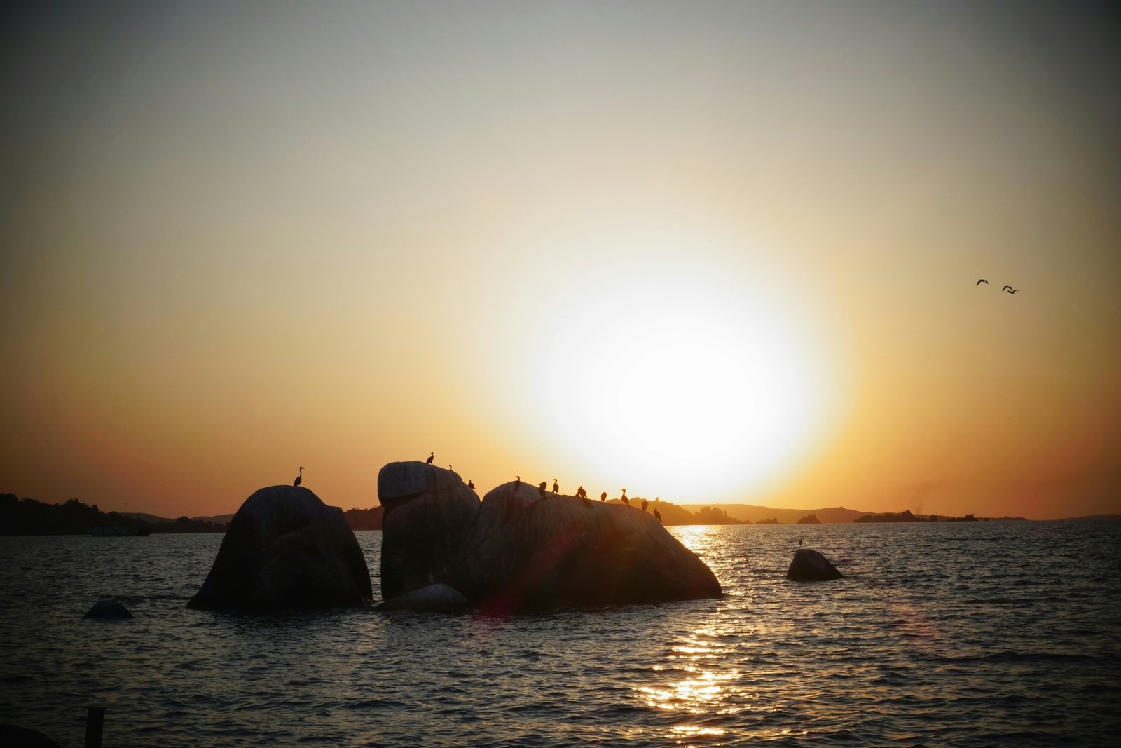 Rock formation silhouetted at sunset on Lake Victoria, Mwanza, Tanzania