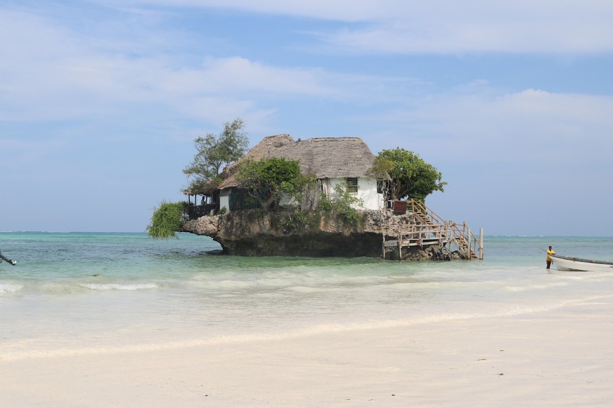 Thatched building on a rocky island in the ocean, Zanzibar, Tanzania