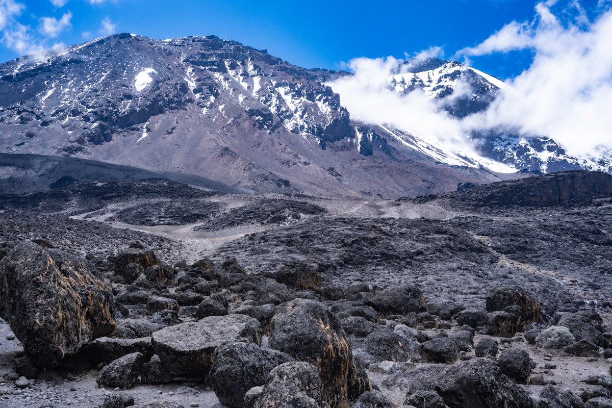 Vast rocky alpine desert on the northern slopes of Kilimanjaro with the snow-capped summit in the background, Tanzania