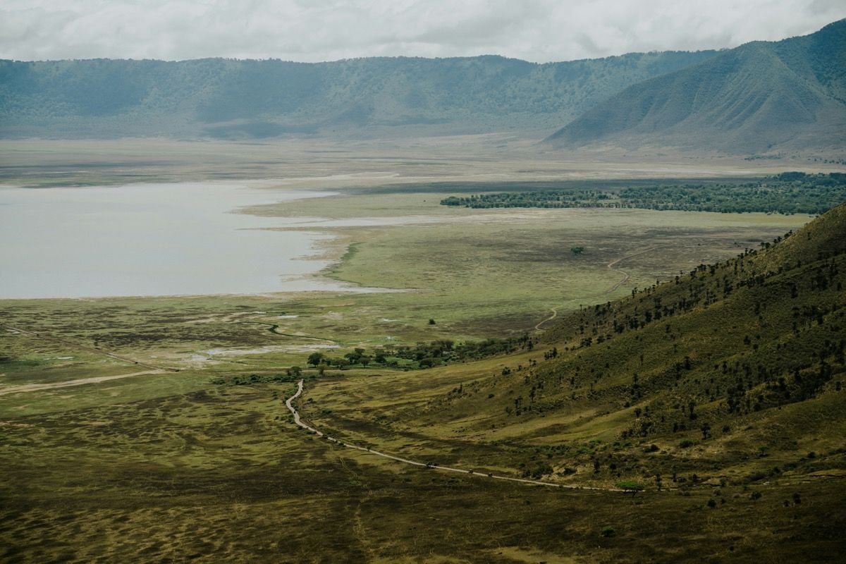 Luftaufnahme des Ngorongoro-Kraterbodens mit See, Grasland und Kraterwänden, Tansania