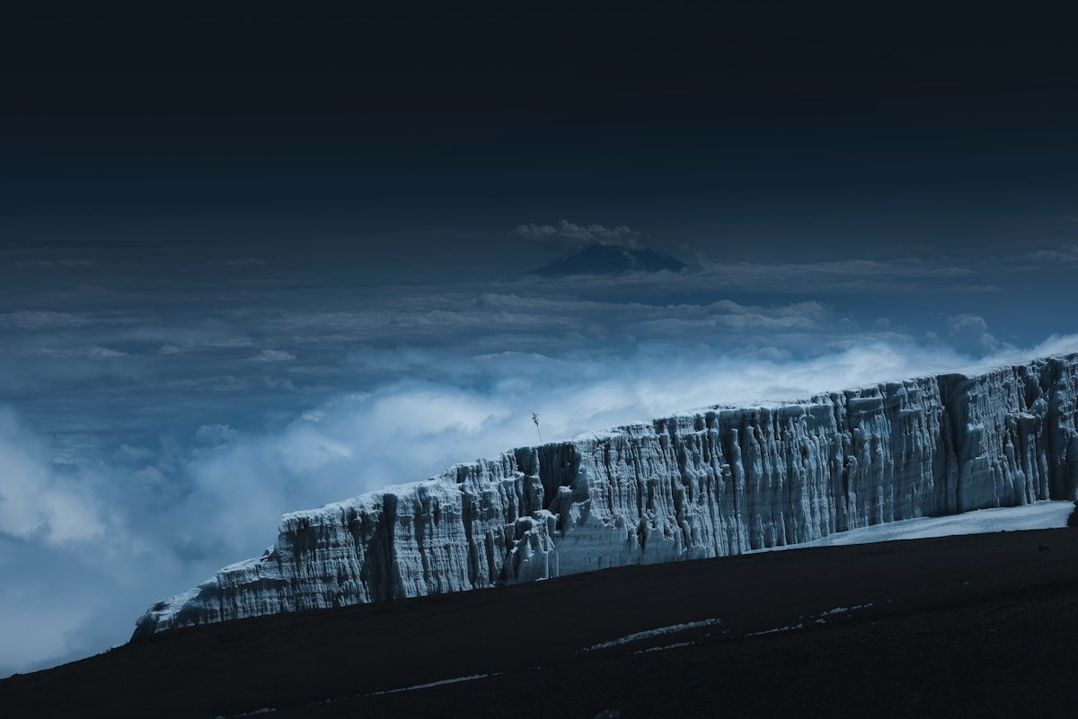 Kilimanjaro glaciers and ice field lit by moonlight above clouds on the summit plateau