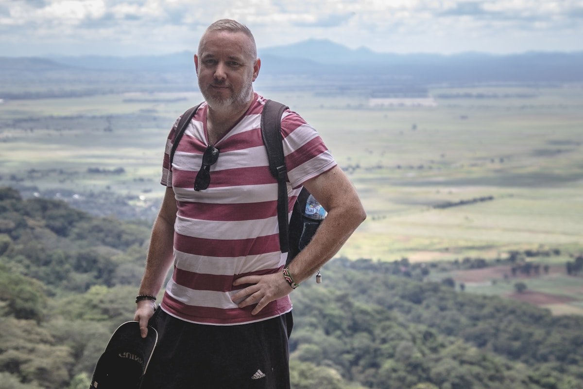Traveller with backpack overlooking a lush Tanzania valley