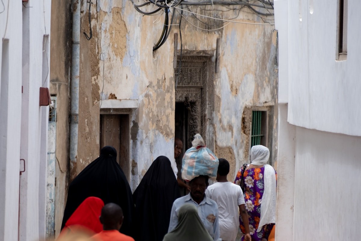 People walking through a narrow street in Stone Town, Zanzibar, Tanzania