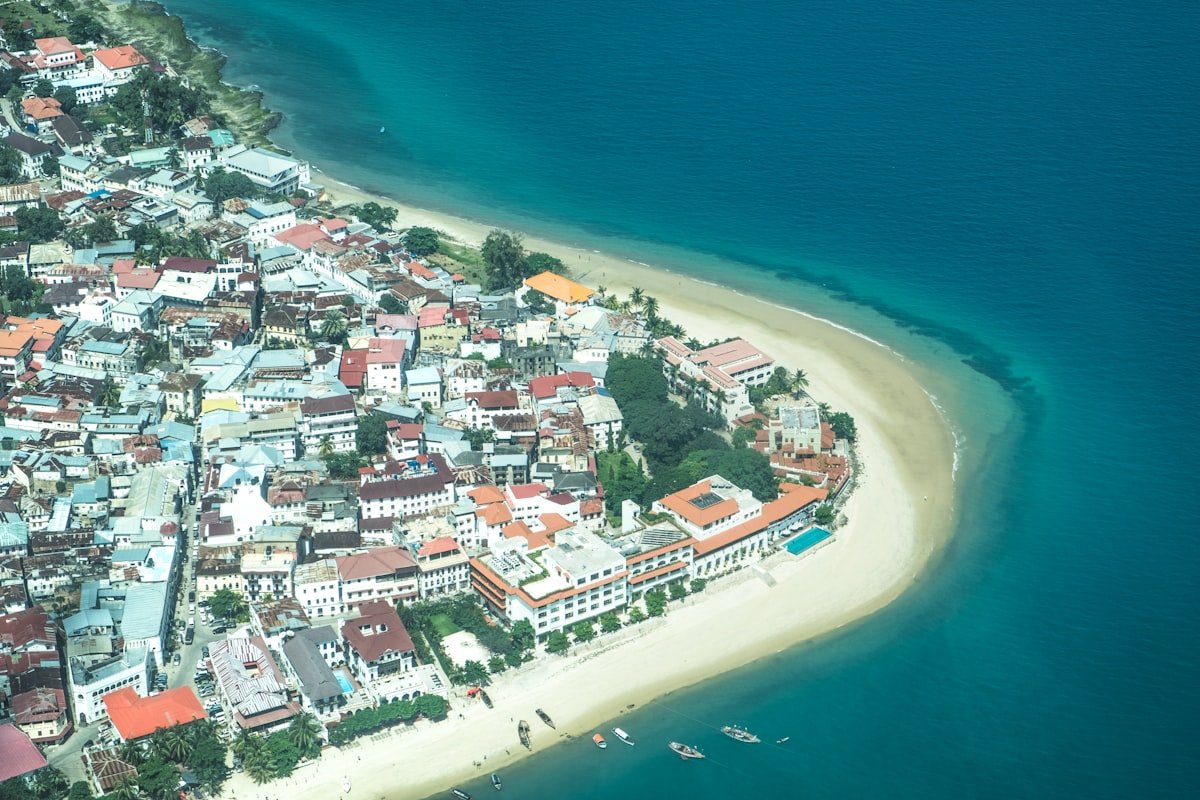 Aerial view of Stone Town, Zanzibar, showing the dense historic buildings and turquoise Indian Ocean